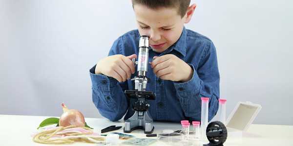 A boy using Buki Microscope with 30 experiments.